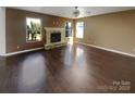 Bright living room with dark wood floors, a stone fireplace, and lots of natural light at 4608 Oakburn Dr, Charlotte, NC 28269