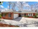Charming brick home featuring an attached garage and a circular driveway with neatly trimmed landscaping at 4633 River Bluff Ct, Charlotte, NC 28214