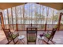 Inviting porch featuring rocking chairs and a table, with scenic view of the lake in the background at 4633 River Bluff Ct, Charlotte, NC 28214