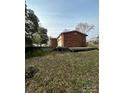 Spacious backyard featuring a wooden deck, brick exterior, and ample lawn space at 502 Mcconnell St, Clover, SC 29710