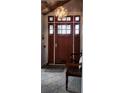 Cozy entryway featuring a stylish light fixture, a wooden bench, and a tiled floor at 5434 Beckhaven Ln, Charlotte, NC 28216