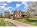 Charming brick home featuring a well-manicured lawn and mature landscaping at 6000 Embassy Ct, Wesley Chapel, NC 28110
