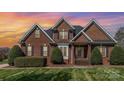 Charming brick home featuring a well-manicured lawn and mature landscaping at 6000 Embassy Ct, Wesley Chapel, NC 28110