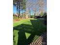 Landscaped backyard featuring artificial turf and a charming wooden pergola at 8011 Greencastle Dr, Charlotte, NC 28210