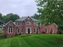 Stately two-story brick home with manicured lawn and mature trees at 8011 Greencastle Dr, Charlotte, NC 28210