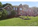 Charming two-story brick residence featuring lush green lawn and mature greenery at 8011 Greencastle Dr, Charlotte, NC 28210