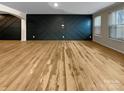 Spacious living room featuring luxury vinyl plank flooring and dark accent wall at 8212 Merryvale Ln, Charlotte, NC 28214