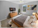 Cozy bedroom features a queen bed, modern decor, neutral colors, and bright natural light at 9144 Cameron Wood Dr, Charlotte, NC 28210