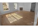 Spacious living room boasts hardwood floors, a fireplace, and ample natural light from large windows at 9144 Cameron Wood Dr, Charlotte, NC 28210