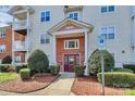 Charming condominium building with well-manicured landscaping, a welcoming entrance, and reserved parking at 10663 Hill Point Ct, Charlotte, NC 28262