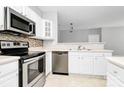 Modern kitchen with stainless steel appliances, white cabinetry, and decorative backsplash at 10663 Hill Point Ct, Charlotte, NC 28262