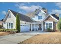 Attractive home featuring neutral siding, a two-car garage, and a welcoming front porch at 11524 Sweet Birch Ln, Charlotte, NC 28278