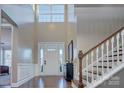 Grand foyer with a soaring ceiling, hardwood floors, and a staircase with white railings at 11524 Sweet Birch Ln, Charlotte, NC 28278