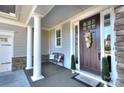 Charming porch with stately columns, a dark front door, and a decorative bench at 11524 Sweet Birch Ln, Charlotte, NC 28278