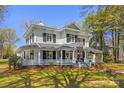 Classic home featuring a wrap-around porch, green shutters, and mature landscaping, exuding Southern charm and elegance at 121 N Congress St, York, SC 29745