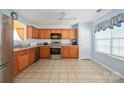 Bright kitchen features stainless steel appliances, tile floors, wooden cabinets, and a sunny window at 1219 Catawba Run Rd, Lowell, NC 28098