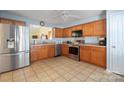 Modern kitchen with stainless appliances, wood cabinets, tile floor, and an open layout, perfect for cooking at 1219 Catawba Run Rd, Lowell, NC 28098