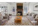 Bright living room features a stone fireplace, hardwood mantle, modern decor and ample seating at 1442 Rainforest Ct, Gastonia, NC 28054
