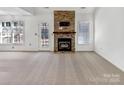 Open-concept living room features a stone fireplace, and a door to outdoor entertaining at 1442 Rainforest Ct, Gastonia, NC 28054