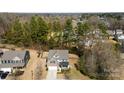 An aerial view shows this two-story home, a manicured front lawn and established landscaping with mature trees at 15916 Foreleigh Rd, Huntersville, NC 28078