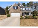 Beautiful two-story home features a manicured lawn, brick accents, and a cozy front porch sitting area at 15916 Foreleigh Rd, Huntersville, NC 28078