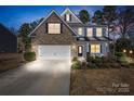 Beautiful two-story home features a manicured lawn, brick accents, and a cozy front porch sitting area at 15916 Foreleigh Rd, Huntersville, NC 28078