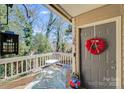 Cozy front porch with a welcoming wreath, seating, and a view of the surrounding greenery at 1606 Sharon W Rd, Charlotte, NC 28210