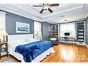 Spacious main bedroom with tray ceiling, hardwood floors, bookshelves, and a comfortable seating area at 1674 Wakefield Way, Rock Hill, SC 29730