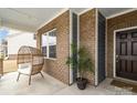 Inviting covered front porch with decorative hanging chair and plant at 1854 Carrollton Dr, Indian Trail, NC 28079