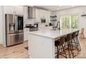 Modern kitchen featuring white cabinets, stainless steel appliances, a large island with seating, and hardwood floors at 207 Windsor Greene Dr, Monroe, NC 28110