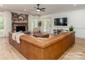 Cozy living room with a stone fireplace, hardwood floors, and large sofa, perfect for relaxing and entertaining at 207 Windsor Greene Dr, Monroe, NC 28110