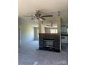 Cozy living room featuring a beautiful fireplace, ceiling fan, and neutral carpet at 24257 Austin Rd, Albemarle, NC 28001