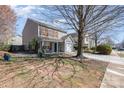 Well-maintained home with a manicured lawn, mature trees, and a visible 