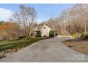 Long driveway leading to a lovely home surrounded by trees and blooming flowers at 3196 Stonemill Path, Sherrills Ford, NC 28673
