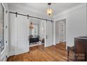 Elegant entryway with sliding barn doors leading to a bright office, showcasing hardwood flooring at 478 Beaty St, Davidson, NC 28036