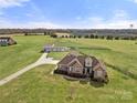 Expansive aerial view of the property, showcasing the home, surrounding land, and outbuildings at 6808 Austin Grove Church Rd, Marshville, NC 28103