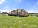 Spacious home featuring a large, green lawn and classic brick architecture at 6808 Austin Grove Church Rd, Marshville, NC 28103