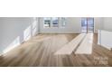 Large bright open living space with light wood floors and large windows at 7120 Saltpeter St, Charlotte, NC 28215
