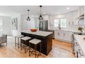 Modern white kitchen featuring a black island with bar stool seating and stainless steel appliances at 7801 Snowden Ln, Charlotte, NC 28270