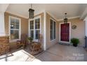 Charming front porch with rocking chairs, decorative lanterns, and a welcoming entrance at 7806 Spanish Oaks Dr, Waxhaw, NC 28173