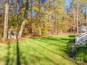 Lush green backyard surrounded by trees, featuring a small garden gazebo and a camper at 10032 Hunters Trace Dr, Concord, NC 28027