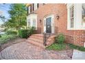 Inviting brick front entrance with black iron railings and a landscaped garden at 1131 S Kings Dr, Charlotte, NC 28207