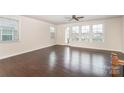 Bright living room featuring hardwood floors, large windows, and a ceiling fan at 11679 Red Rust Ln, Charlotte, NC 28277