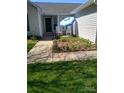 Charming front yard with a blue umbrella, chairs, and landscaped flower bed adding curb appeal at 11910 Lorden Ave, Charlotte, NC 28213