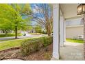 View of a well-kept front lawn and a charming house from under a covered porch at 13514 Porter Creek Rd, Charlotte, NC 28262