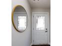 Inviting foyer with white door, transom window, wood floors, and a stylish round mirror at 1814 Shumard Ln, Charlotte, NC 28205
