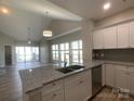 Modern kitchen featuring granite countertops, stainless steel appliances, white cabinets, and a spacious island with a sink at 18840 Nautical Dr # 57, Cornelius, NC 28031