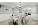 Elegant dining room with a modern white table, complemented by stylish chairs and an open view into the living room at 311 Glenn Allen Rd, Mooresville, NC 28115