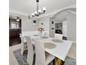 Elegant dining room with a modern white table, complemented by stylish chairs and an open view into the kitchen at 311 Glenn Allen Rd, Mooresville, NC 28115
