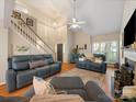 Inviting living room with high ceilings, a cozy fireplace, and comfortable blue leather seating at 3229 Leicester Dr, Matthews, NC 28104